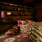 Deep red botanical floral linen pillowcases on a richly styled boho bedroom bed, wide room view