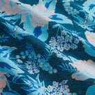 Macro detail of teal linen fabric with blue and blush pink floral botanical print showing texture