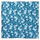 Flat-lay of square teal and blush floral tablecloth with peach scalloped border