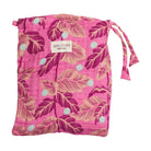 Pink baby wrap folded in drawstring storage bag with tropical leaf print and brand label