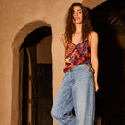 Multicolor patchwork print cami top with V-neckline and thin straps, tucked into wide-leg jeans