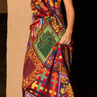 Detail shot of the multicolour patchwork-print satin slip skirt showing bold floral, geometric and bamboo motifs