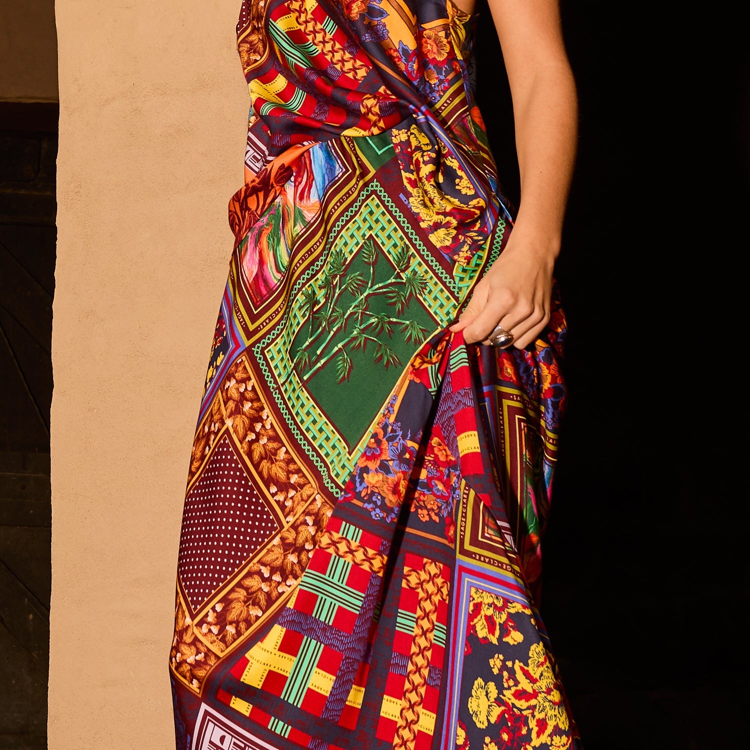 Detail shot of the multicolour patchwork-print satin slip skirt showing bold floral, geometric and bamboo motifs
