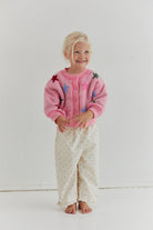 Full front view of pink star cardigan with button placket and crew neckline