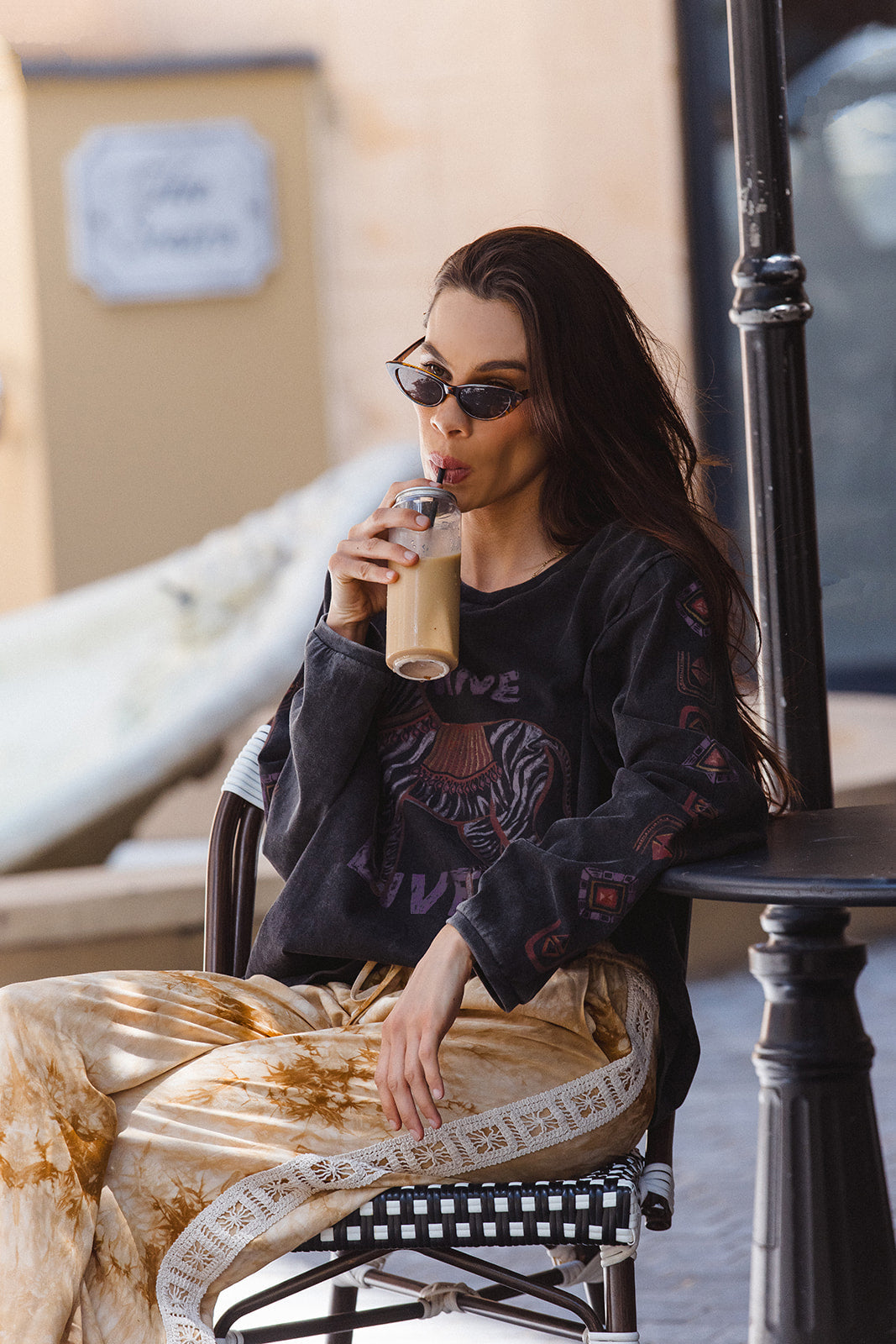 Lifestyle shot of Sunday Pants in sand showing tie-dye pattern and relaxed casual styling