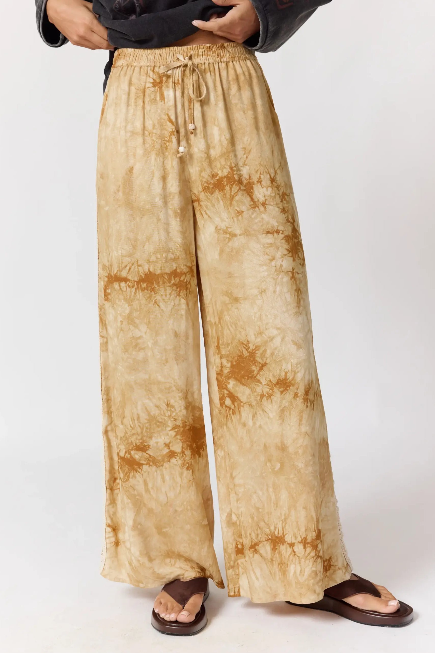 Front view of Sunday Pants in sand showing tie-dye pattern and wide leg silhouette with drawstring waist