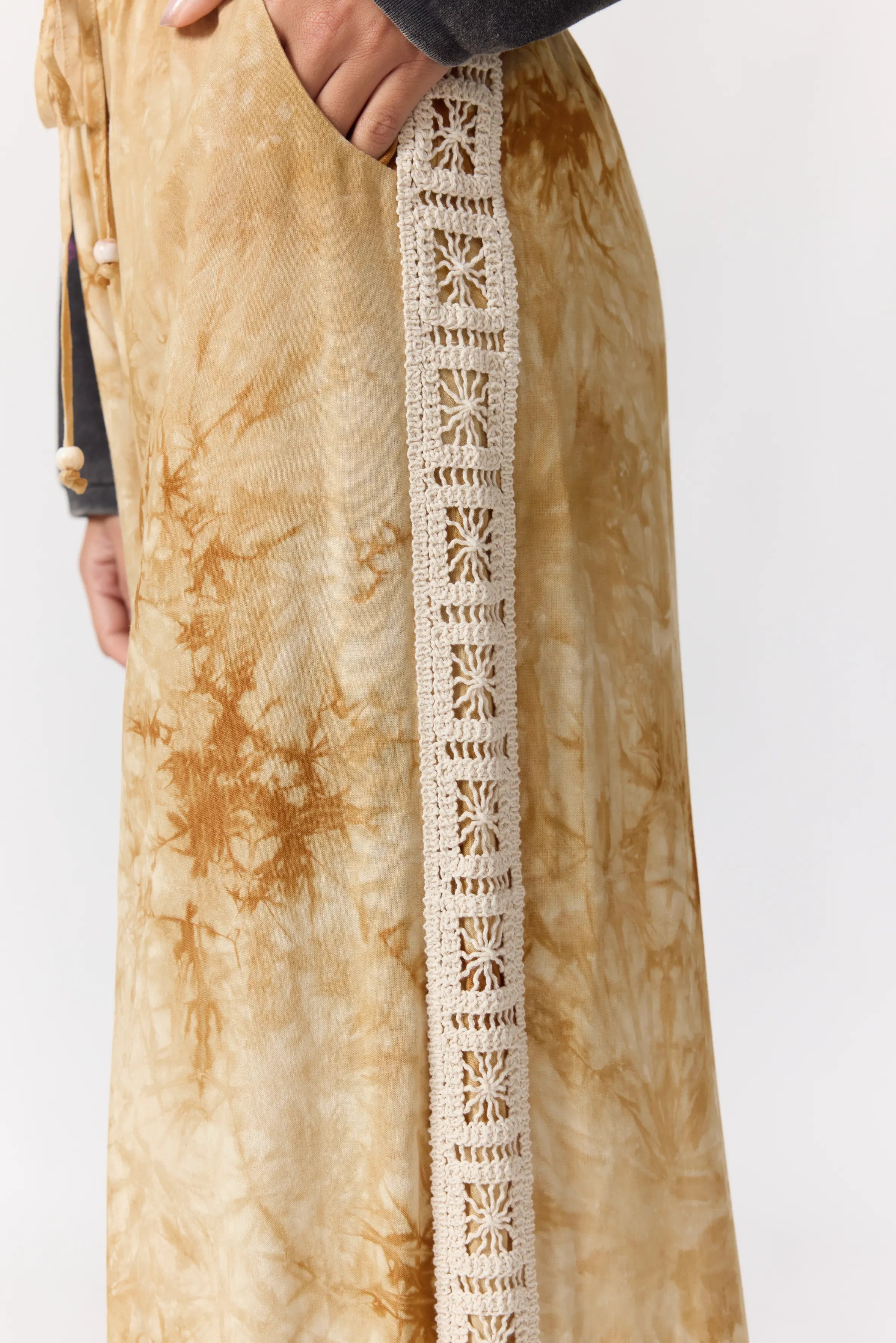 Side view of Sunday Pants displaying cream crochet lace trim detail along outer seam