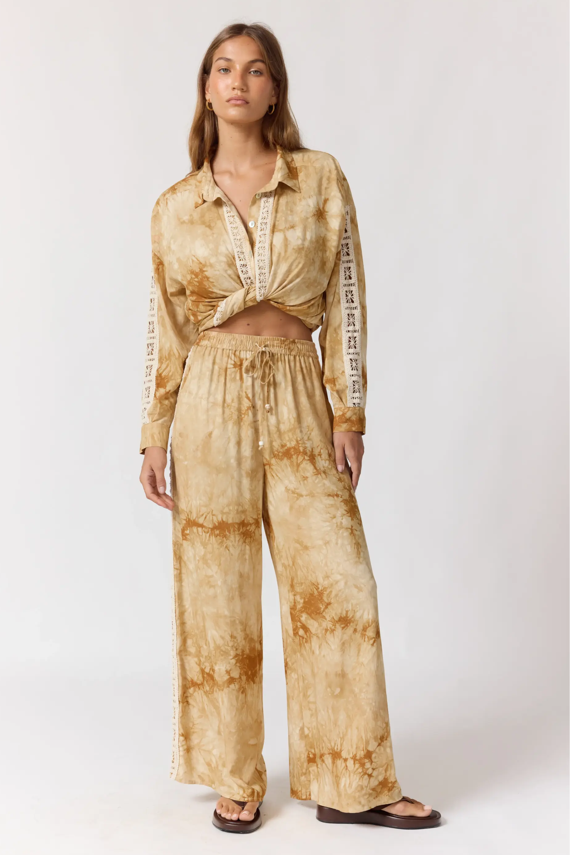 Full body front view of Sunday Pants in sand with tie-dye pattern and relaxed wide leg fit