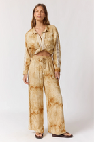 Full body front view of Sunday Pants in sand with tie-dye pattern and relaxed wide leg fit