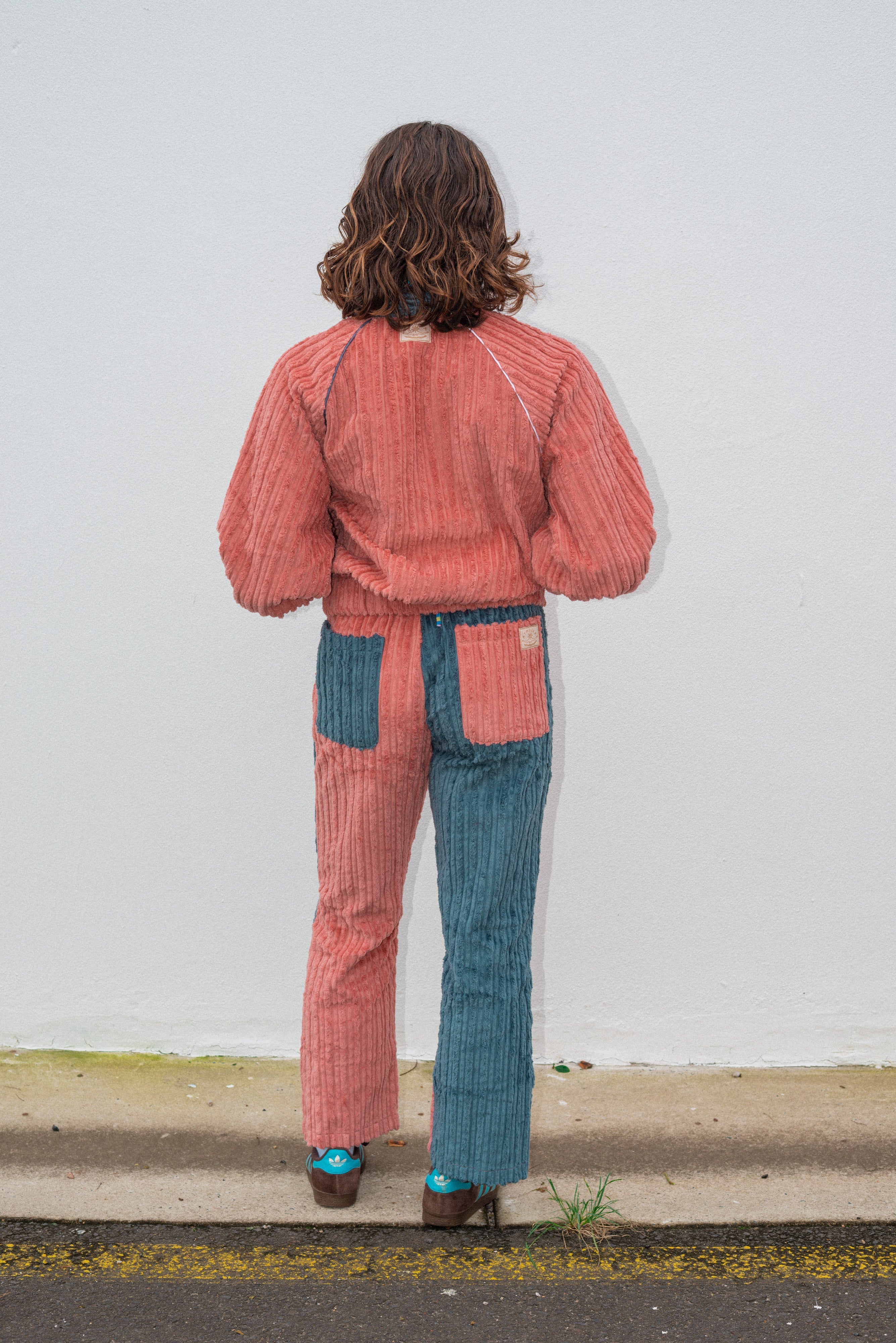 Back view of two tone pink and blue corduroy surf bomber jacket showing ribbed corduroy texture and relaxed fit