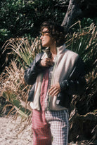 Woman wearing the cream front zip vest in size M layered over a flannel shirt in a coastal bush setting