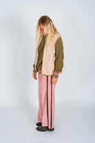 Three-quarter side view of the cream front zip vest in size M showing silhouette and olive trim detail