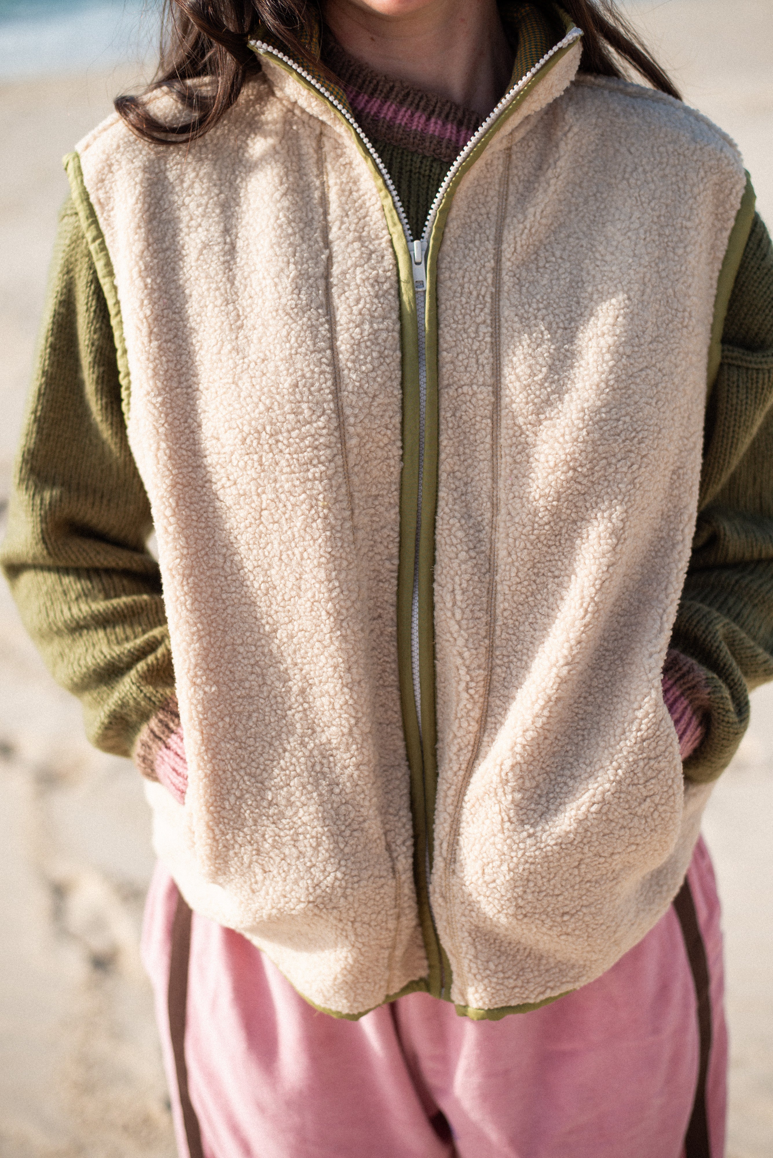 Close-up front detail of the cream front zip vest in size M showing fluffy sherpa texture and centre front zip