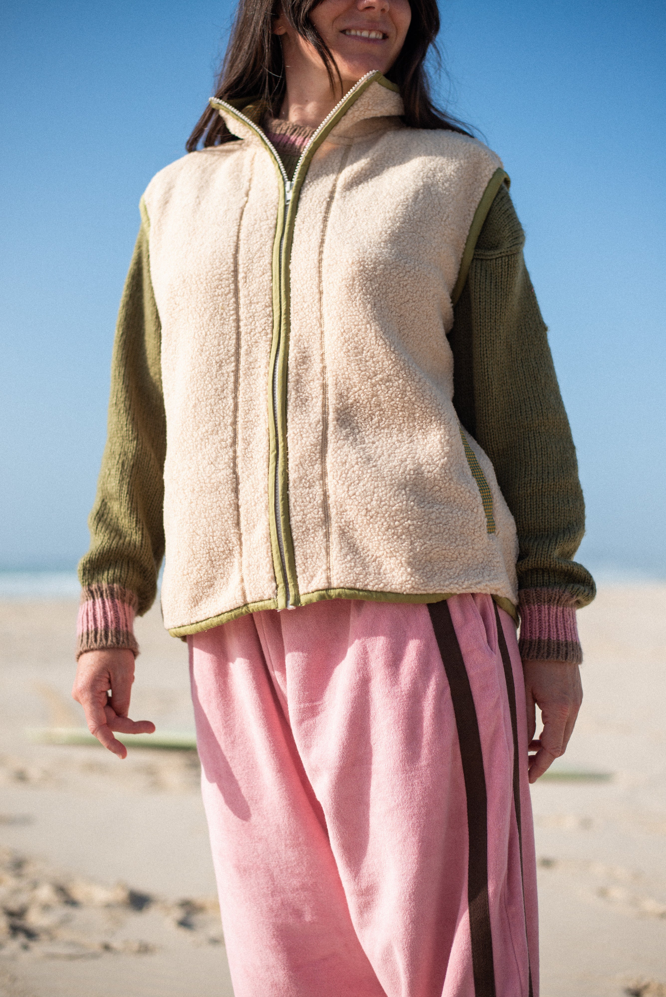 Outdoor beach shot of the cream front zip vest in size M with houndstooth lining worn on a sunny day