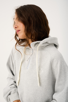 Side angle of grey marle Teagan Hoodie highlighting hood drawstrings and oversized silhouette