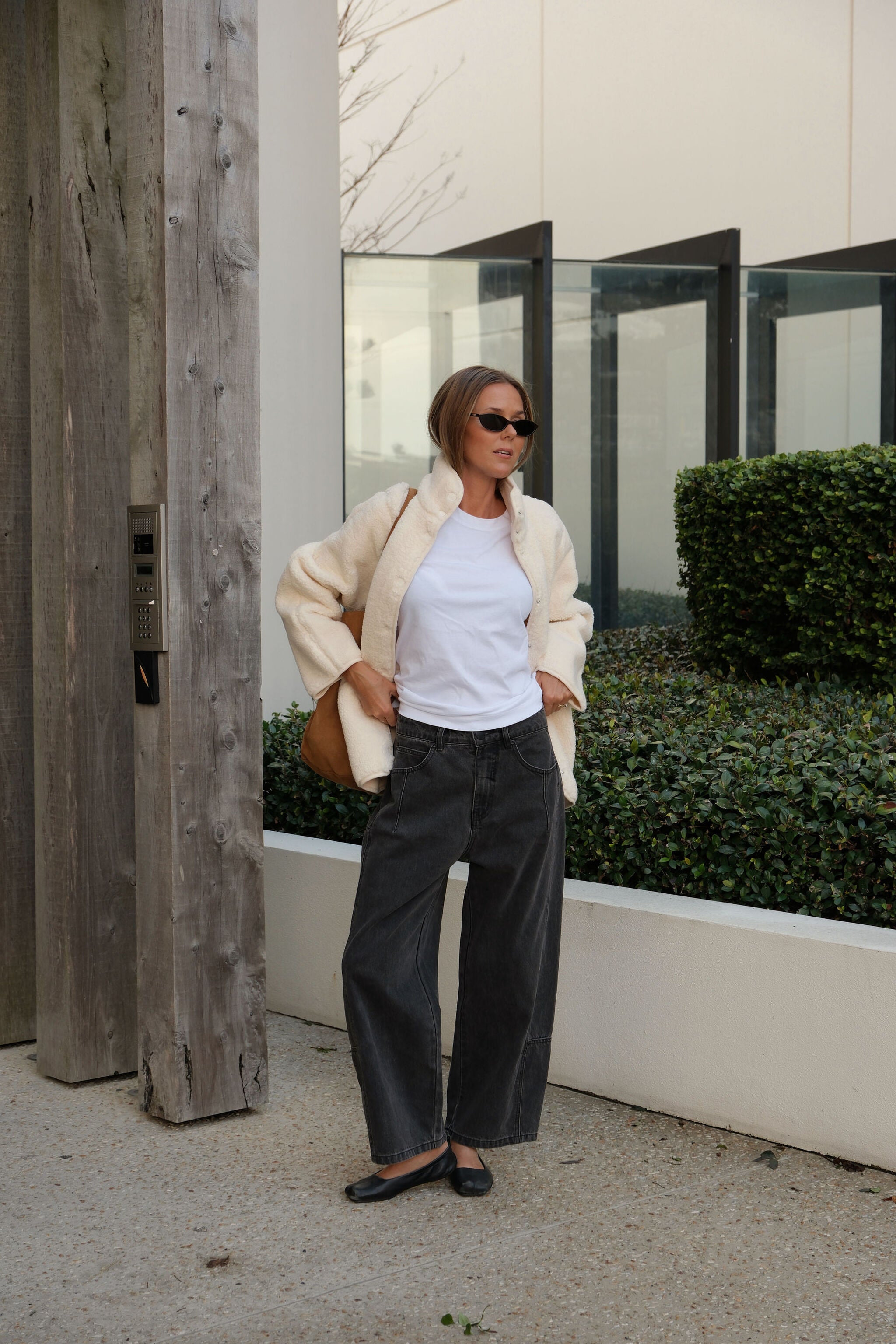 Woman styling marshmallow teddy jacket open over white tee with casual street look