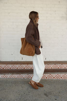 Side profile of chocolate brown teddy jacket highlighting oversized sleeves and cozy sherpa material