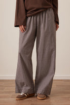 Front view of chocolate check lounge pants on model showing wide leg fit and elastic waist
