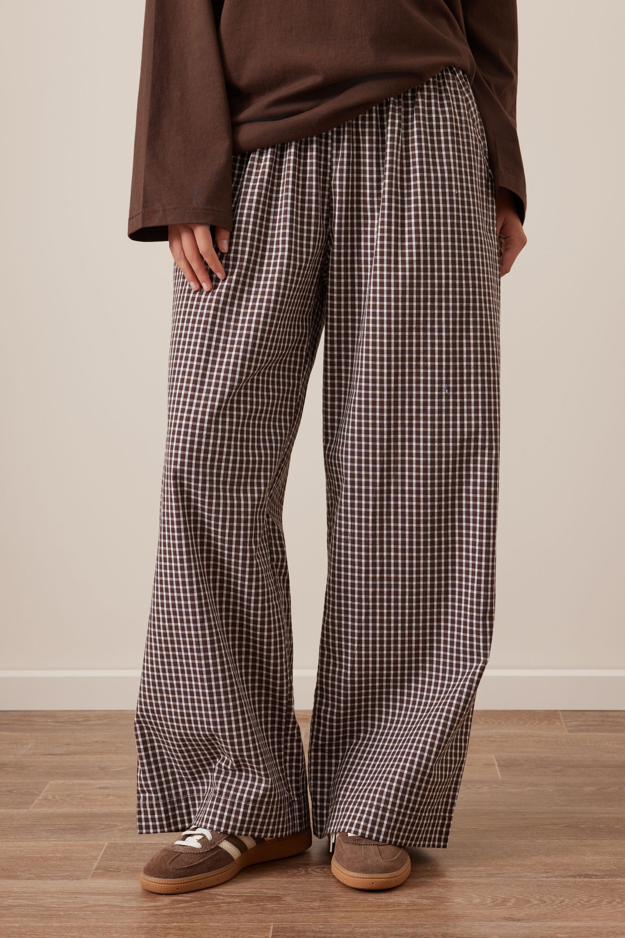 Front view of chocolate check lounge pants on model showing wide leg fit and elastic waist