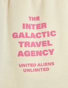 Close-up of Inter Galactic Travel Agency text print in pink lettering on cream fabric
