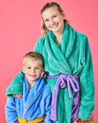 Mother and son wearing matching Tropicas robes in teal and blue with purple and yellow belts