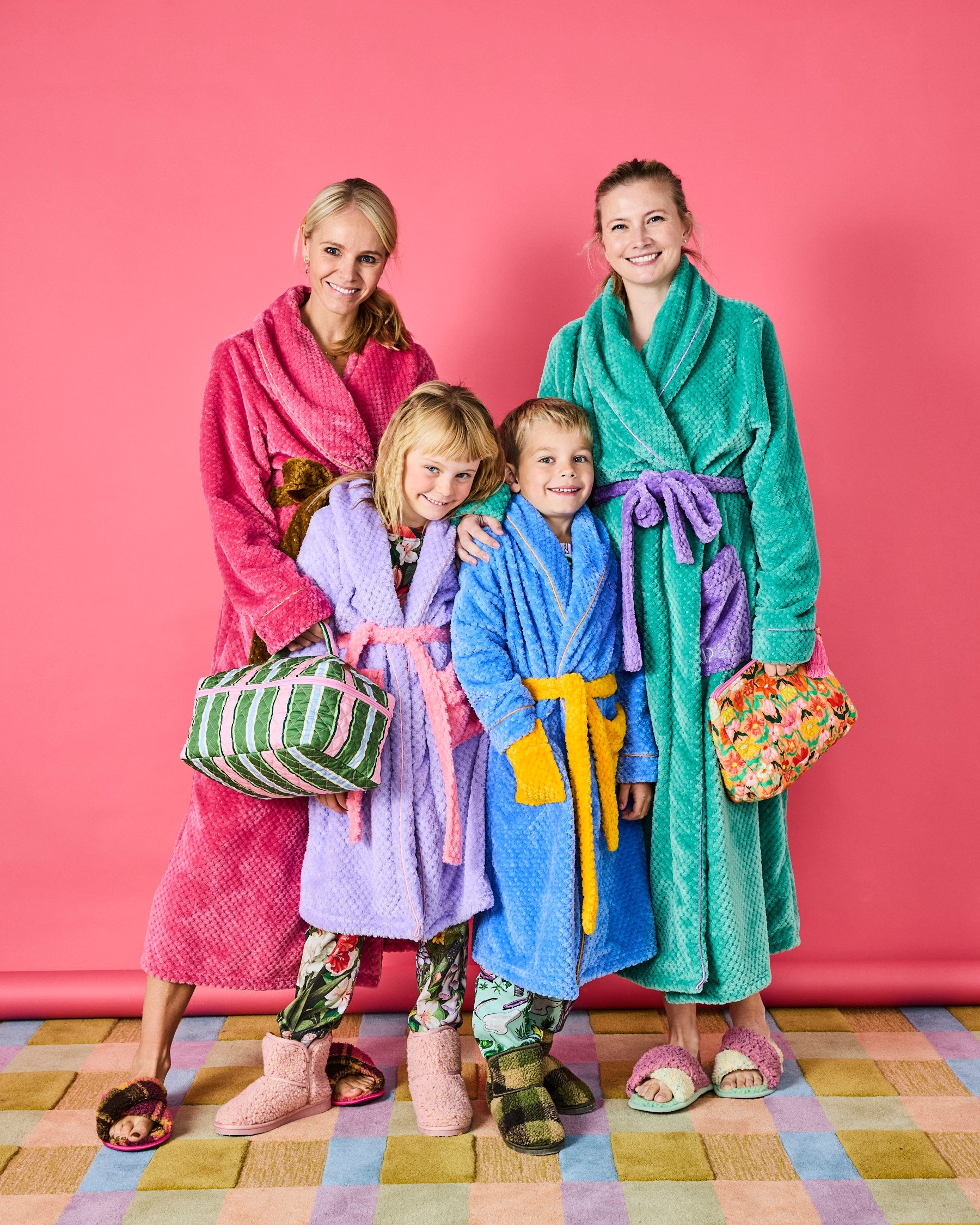 Family group wearing colorful Tropicas Cosy Robes in teal, pink, purple and blue with waffle texture