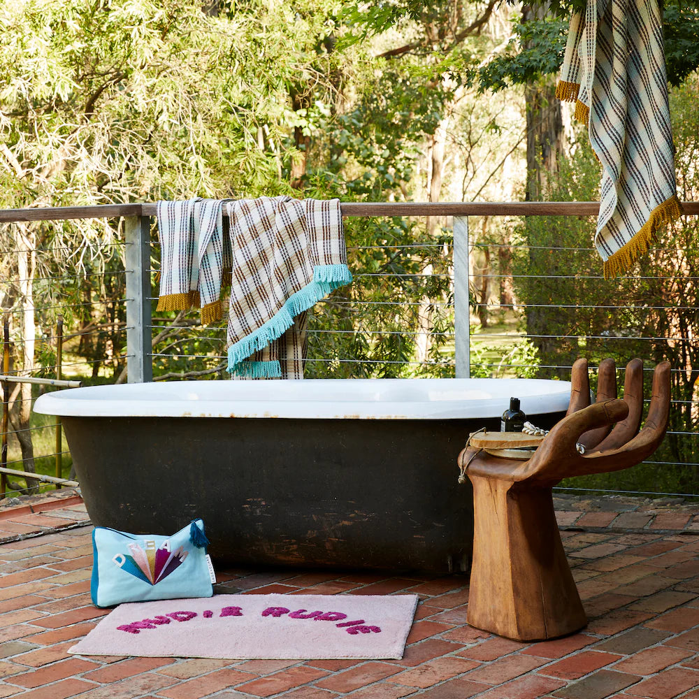 Tula Nudie Rudie Bath Mat Blush Sage & Clare lifestyle photo in front of outdoor bath tub