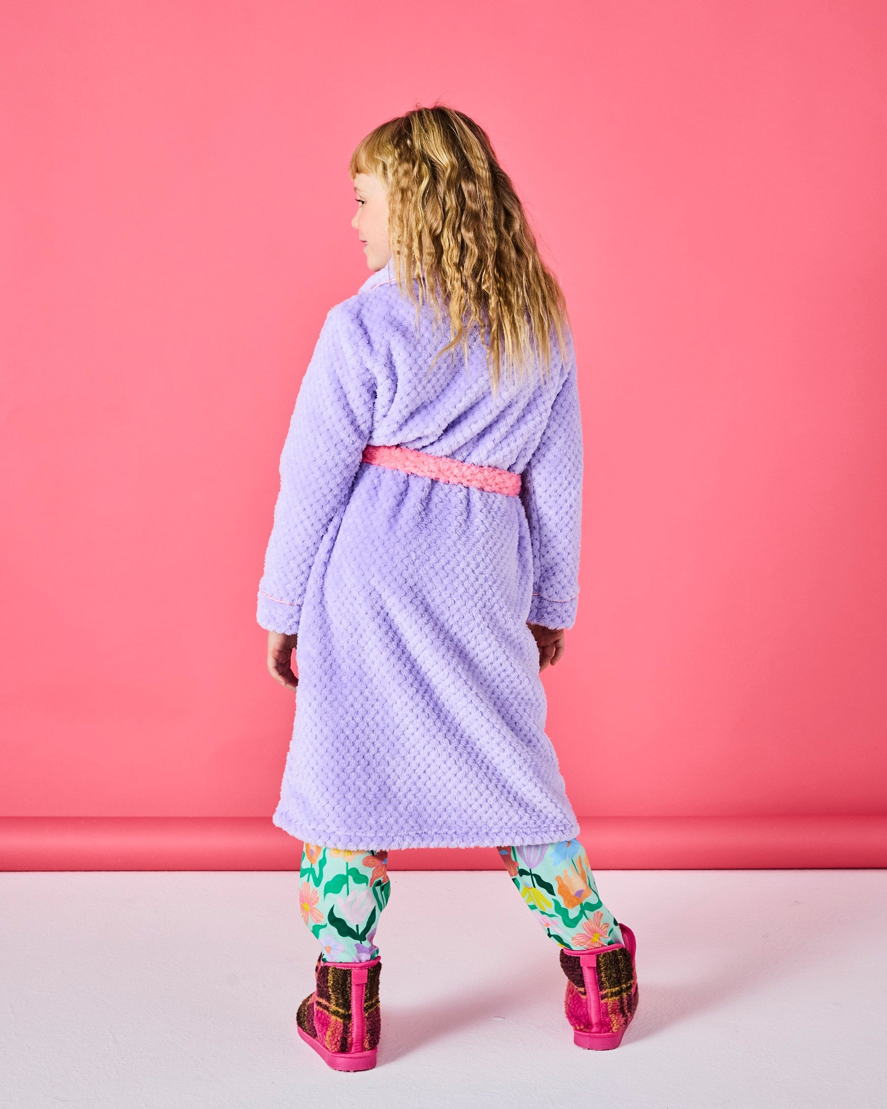 Back view of child in purple Tulip Kids Cozy Robe with pink belt showing full length silhouette
