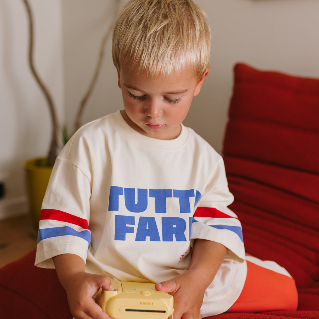 Young boy wearing the Tutto Fare T-shirt - Buttercream | Golden Children