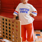 Girl in the blue, red and white Tutto Fare T-shirt - Buttercream | Golden Children
