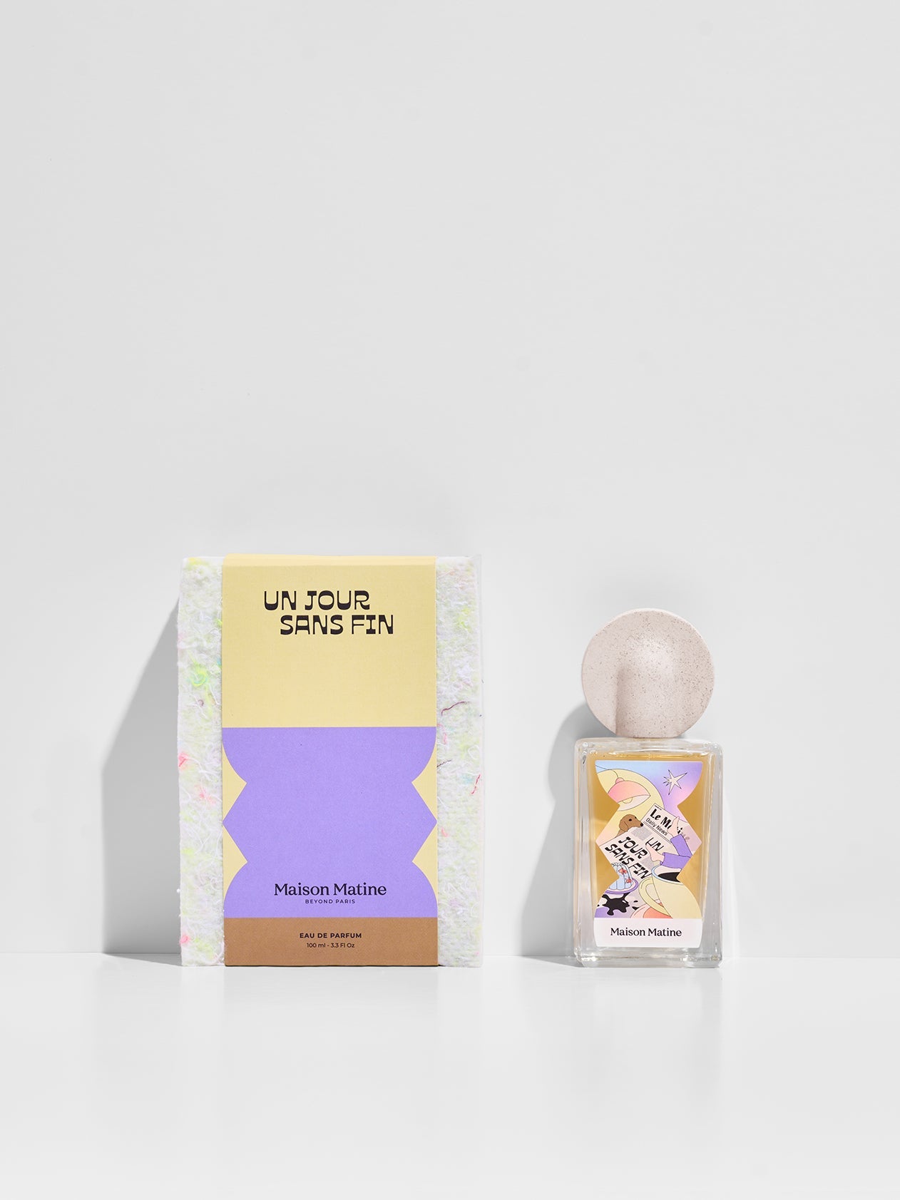 Un Jour Sans Fin perfume bottle and yellow purple packaging box displayed together on white surface