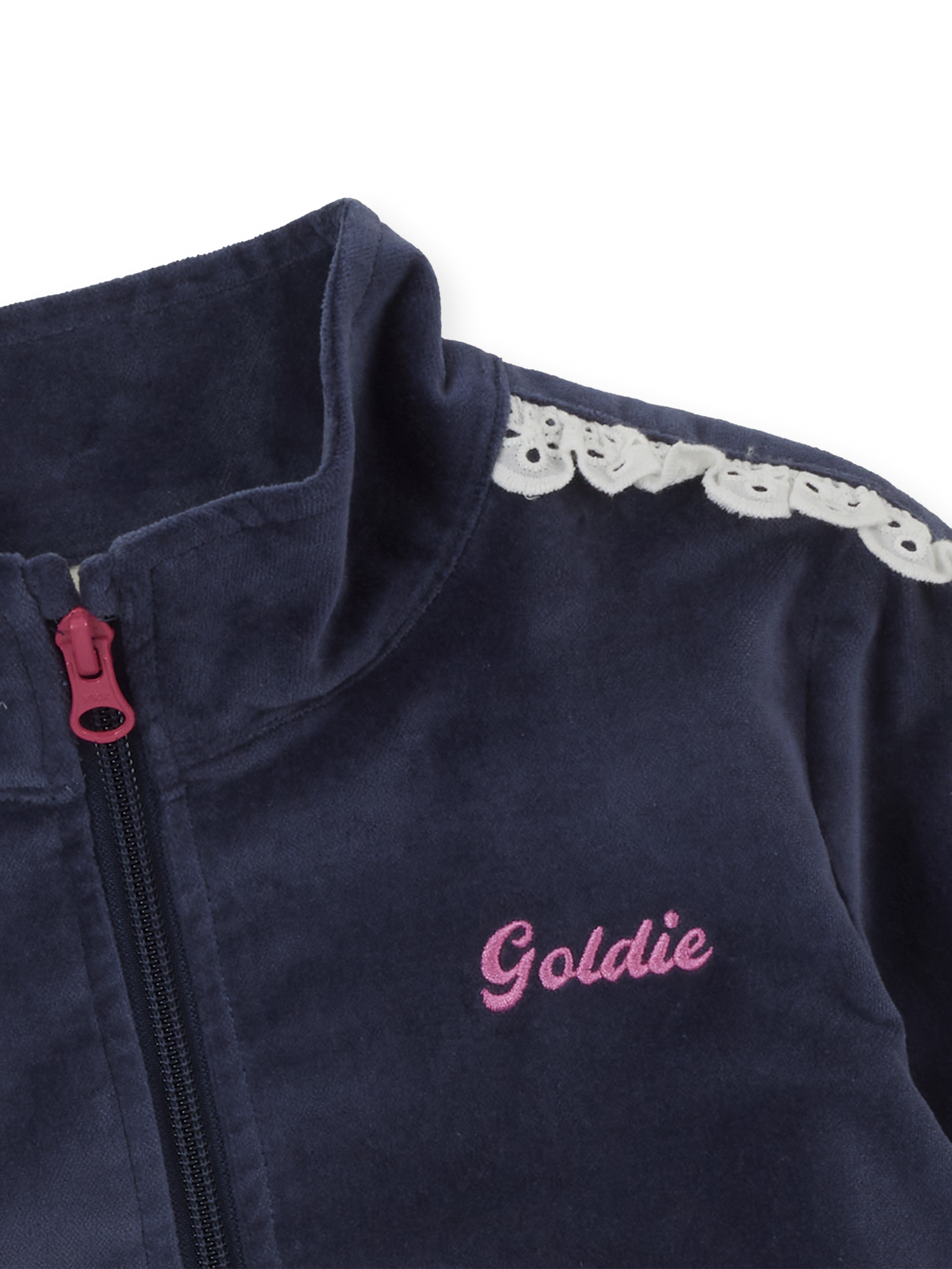 Detail shot of navy velour jacket showing pink zipper pull and white broderie lace trim on shoulder