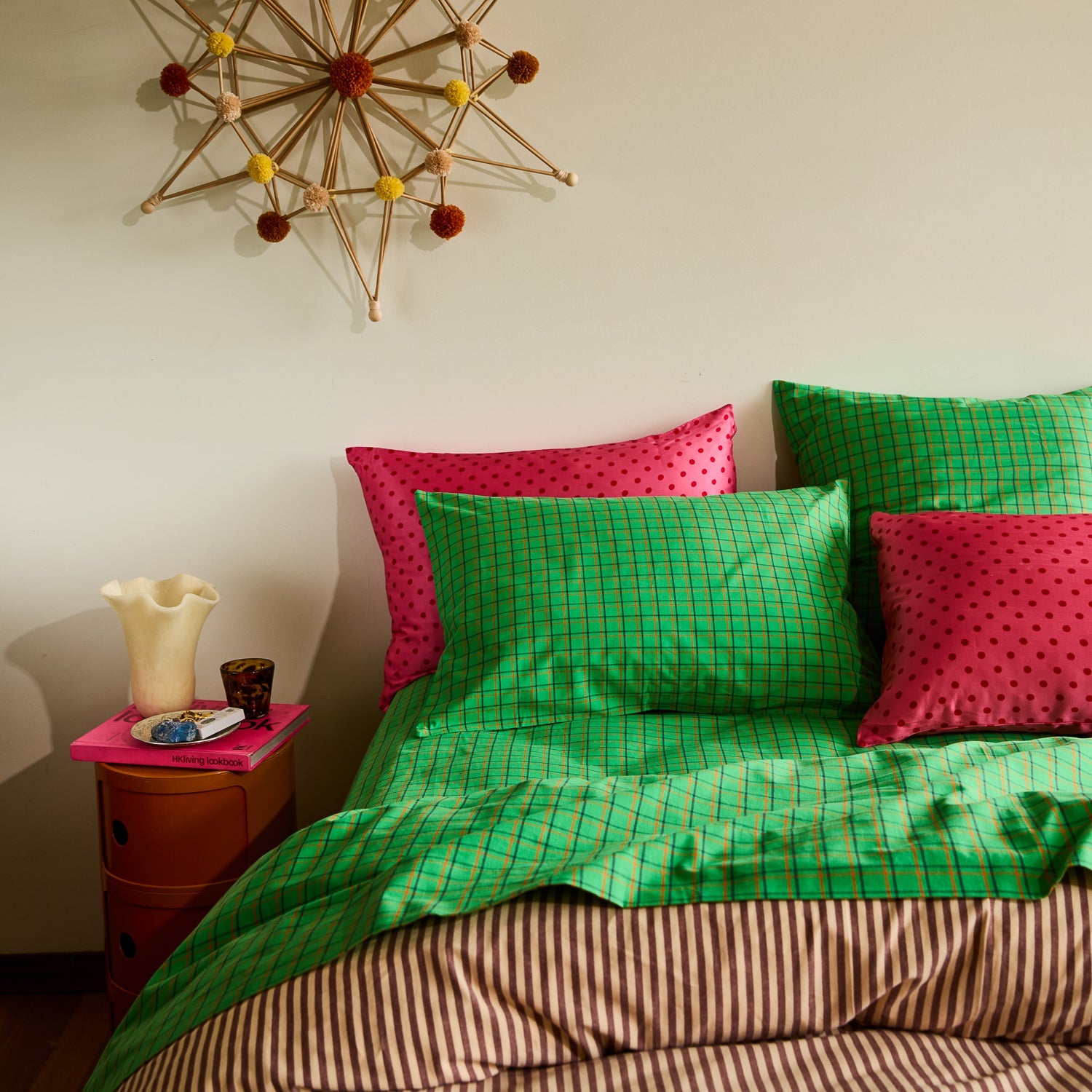 Pearl Violetta Vase on a bedside table styled beside colorful patterned bedding in a vibrant bedroom