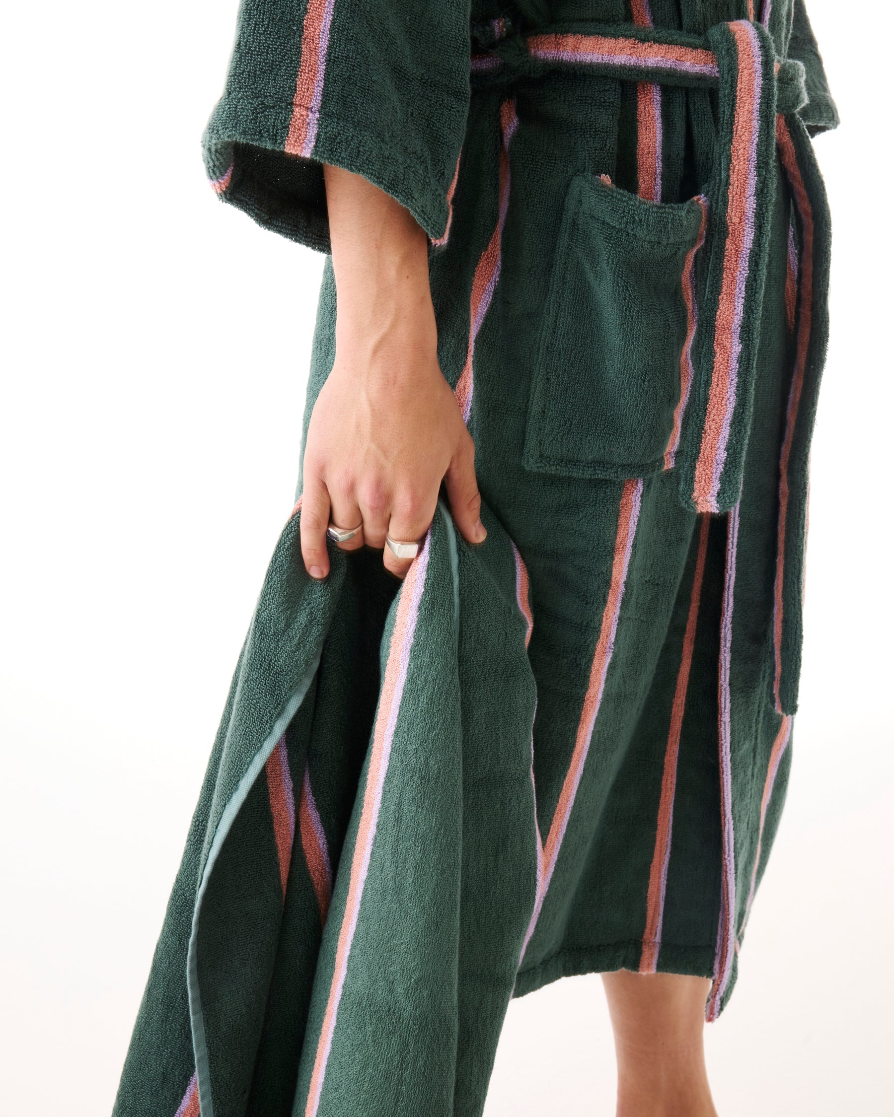 Side view of woman wearing green striped bamboo terry robe showing belt tie and pocket detail