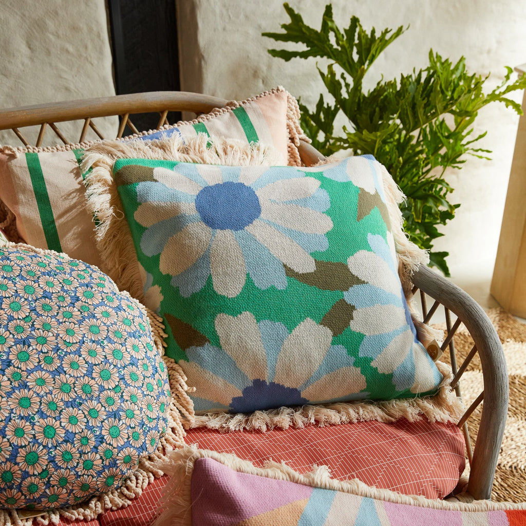 Knit cushion from Sage & Clare with blue flowers and green background