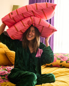 Model holding Wategos Soiree quilted pillowcase overhead showing pink color and orange stripe pattern