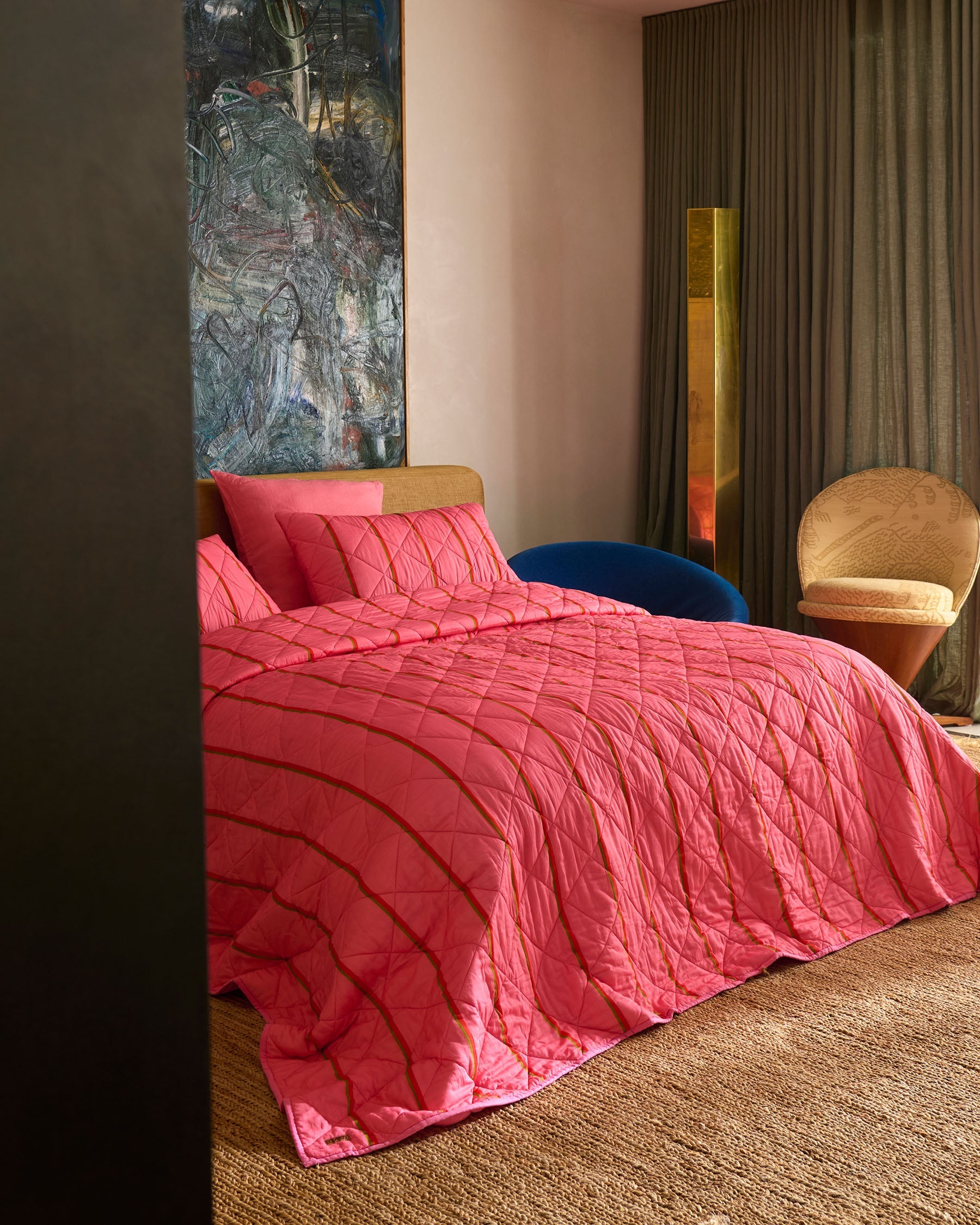 Wategos Soiree Stripe pink quilted bedspread by Kip Co draped over bed in modern bedroom setting