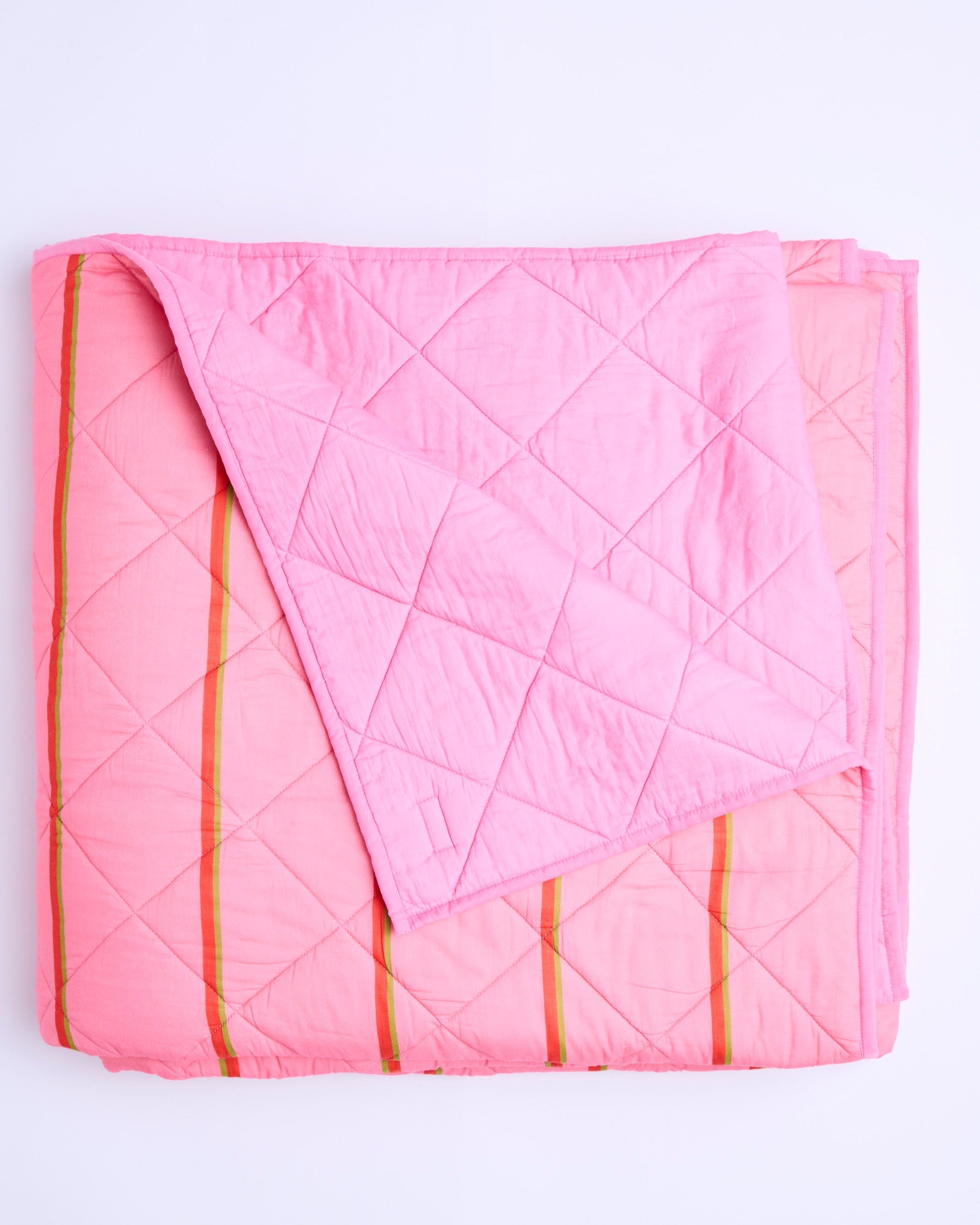 Flat lay view of Wategos Soiree Stripe quilted bedspread showing full diamond quilting pattern and orange stripes