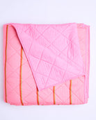 Flat lay view of Wategos Soiree Stripe quilted bedspread showing full diamond quilting pattern and orange stripes