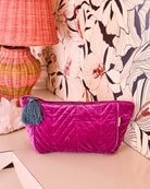 Wild Grape Velvet Toiletry Bag by Kip Co with quilted pattern and teal tassel on neutral surface