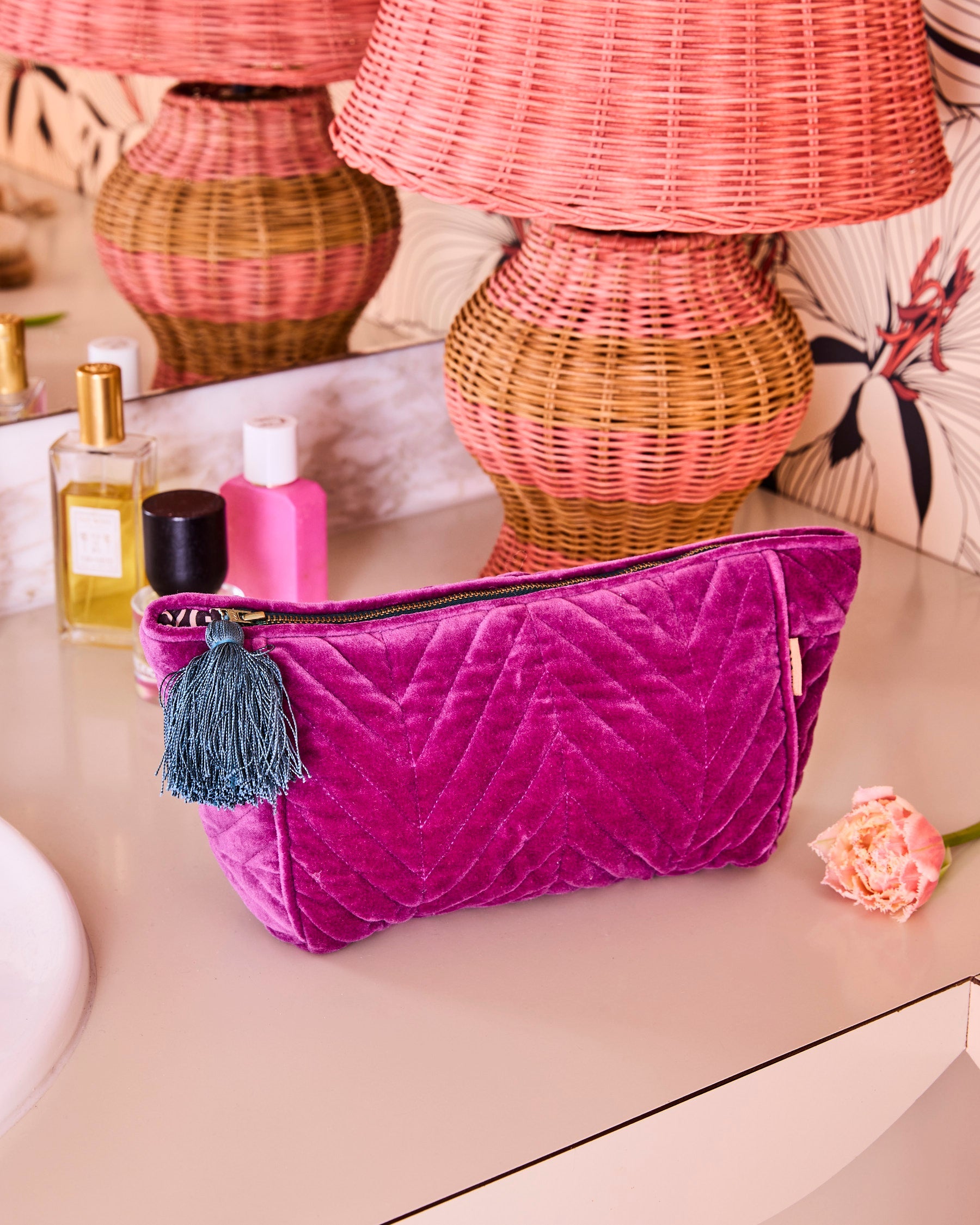 Kip Co Wild Grape toiletry bag styled with beauty products and wicker baskets in boho setting