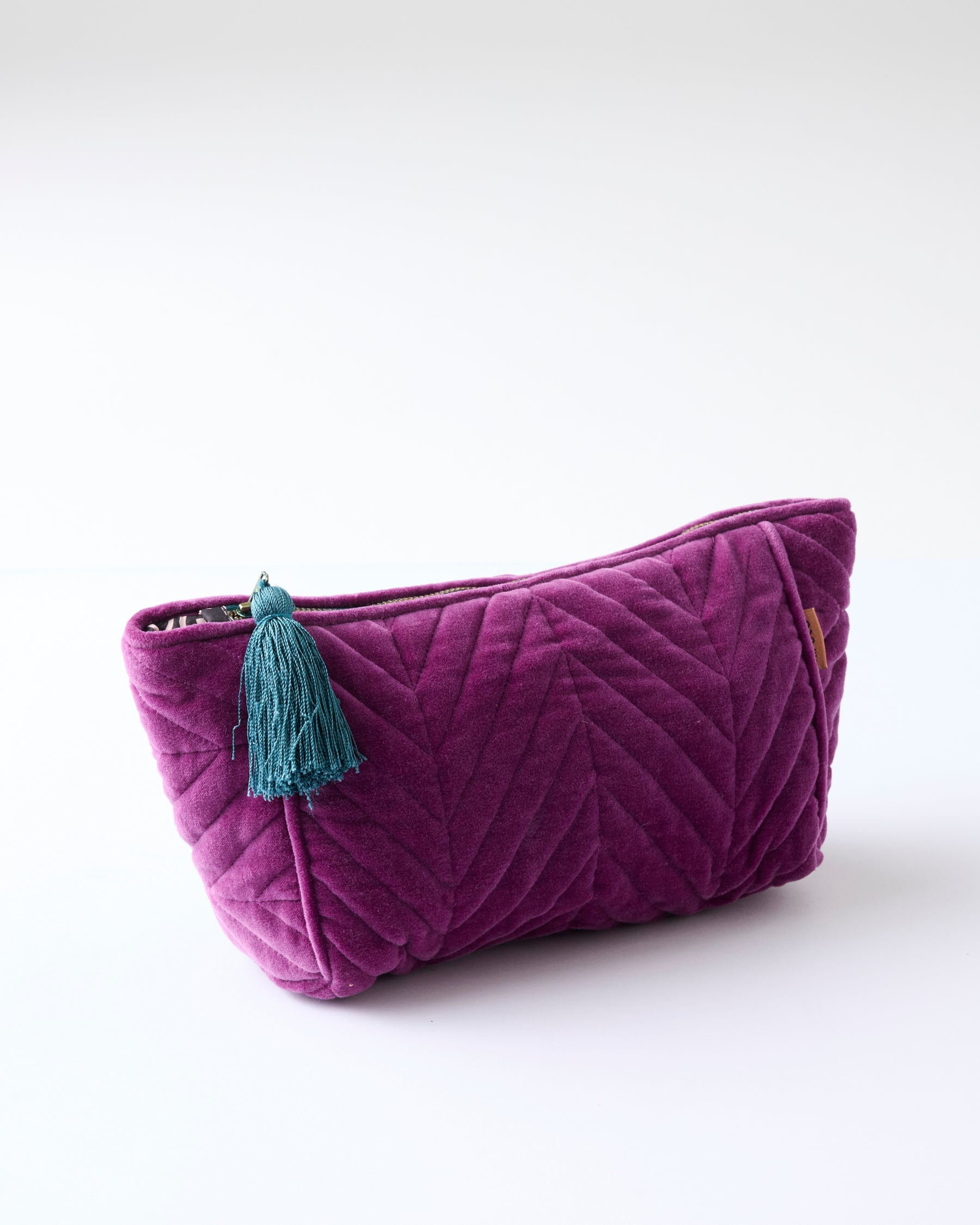 Wild Grape Velvet Toiletry Bag by Kip Co isolated view showing quilted pattern and tassel charm