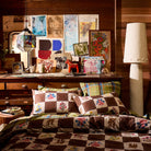 Two brown checkerboard folk floral print cotton pillowcases on a bed in an eclectic styled bedroom