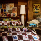 Cotton quilt cover in brown and cream checkerboard with colourful floral and bird motifs on a styled bed