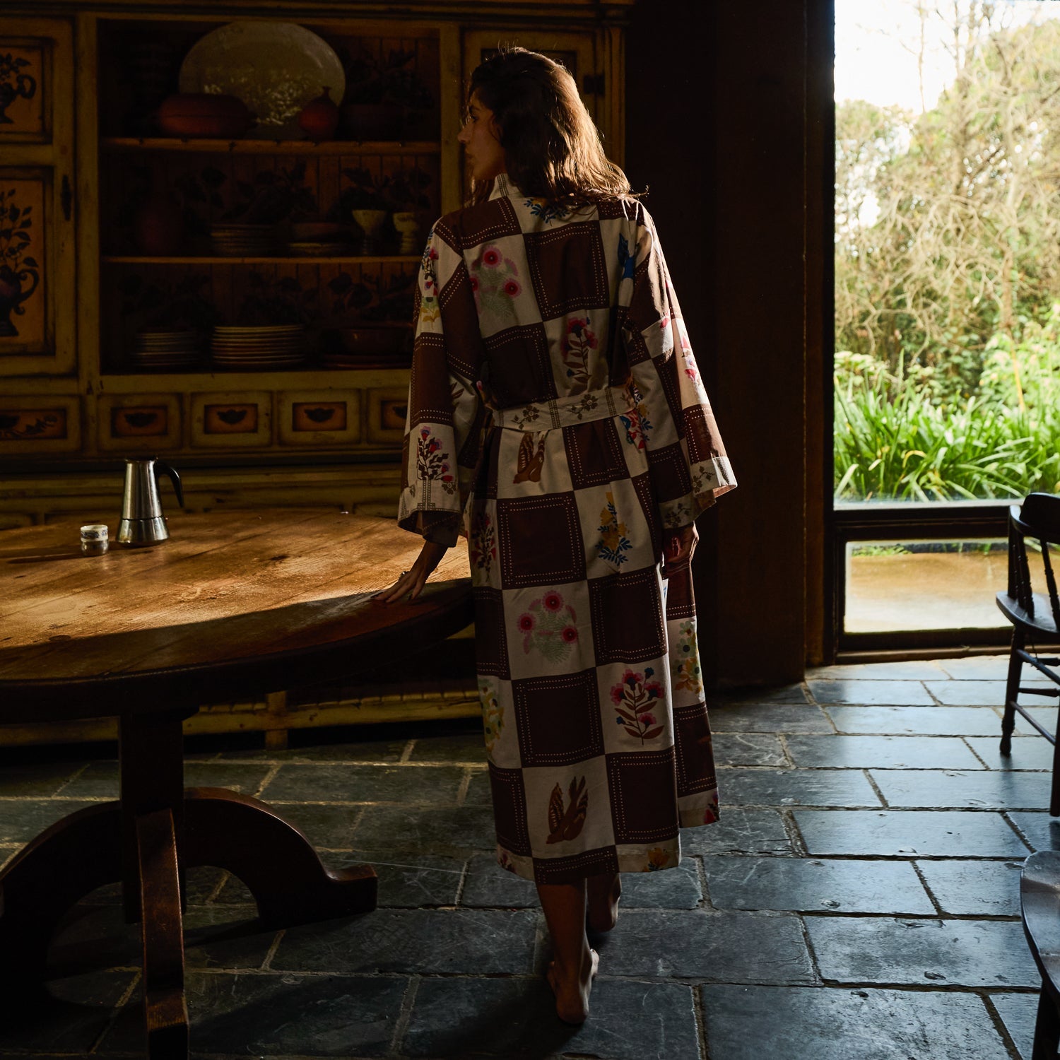 Back view of cotton robe in brown and cream checkered print with bird and floral motifs, showing full midi length and belted waist
