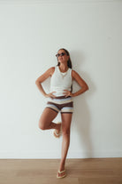 Full length studio shot of brown, cream and blue striped knit shorts styled casually