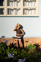 Studio styling shot featuring brown, cream and blue striped knit shorts with polka dot cami top