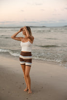Side profile view of striped knit shorts showcasing horizontal band design in brown, cream and blue colors