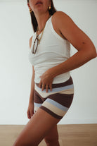 Studio front view of striped knit shorts with horizontal brown, cream and blue bands on model