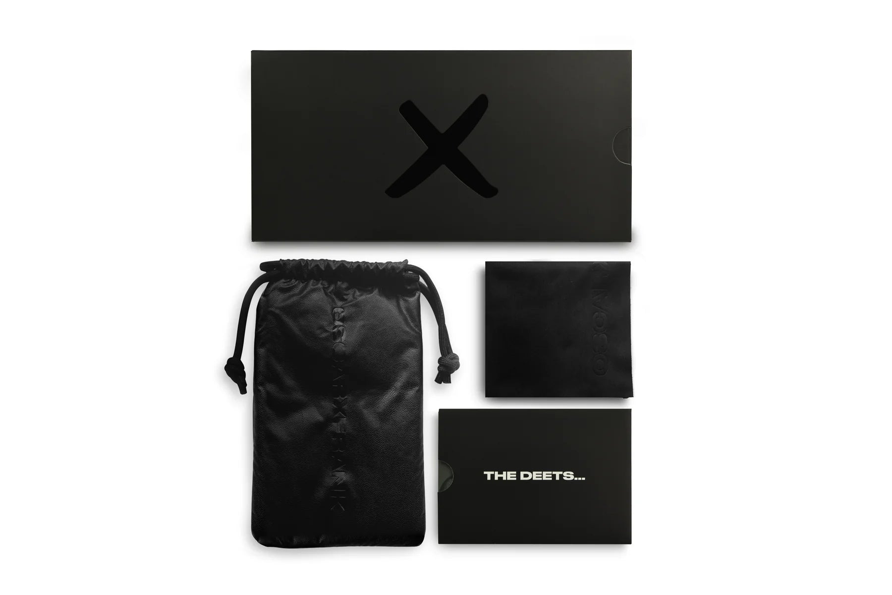 Black product packaging set with drawstring bag, card, and box on a white background